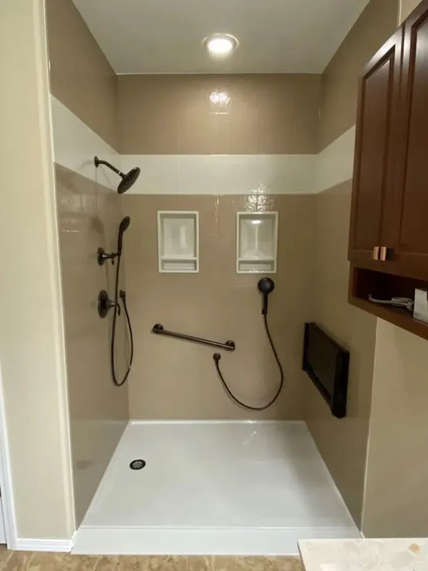 ADA walk-in shower with oil-rubbed bronze multi-head fixtures, dual niches, grab bar and handheld sprayer for aging-in-place