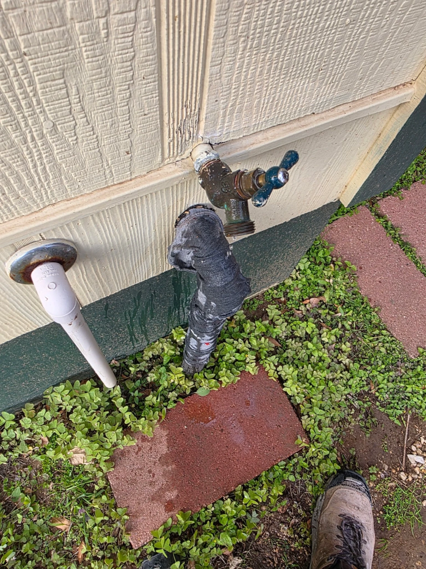 Before photo: corroded outdoor hose bib with leaking joint and broken supply line at the foundation of a San Antonio home