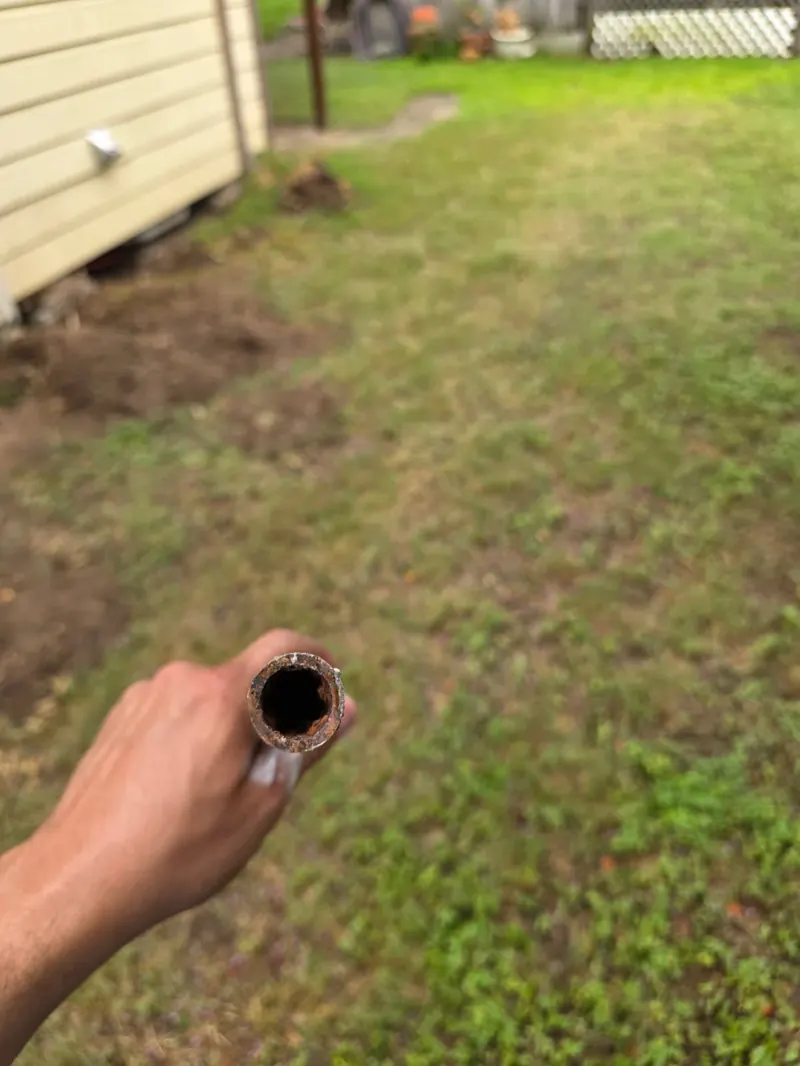 Cutoff section of rusted galvanized water supply pipe removed during a San Antonio repipe — heavy internal corrosion causing low pressure and discolored water